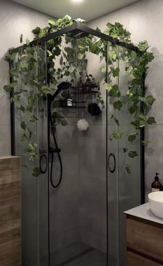 a shower with plants growing on the side of it and a sink in front of it