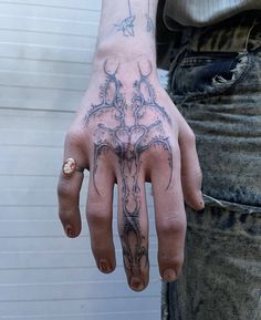 a person's hand with a tattoo on it and a ring in the middle