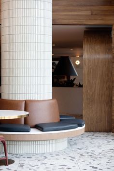 the interior of a modern restaurant with round tables and chairs, along with tiled flooring