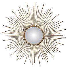 a gold sunburst mirror on a white wall