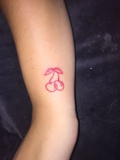 a small tattoo on the leg of a woman's foot, with cherries