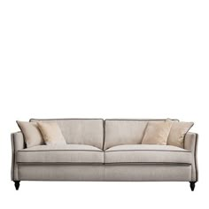 a white couch with pillows on it and a light colored back rest in front of a white background