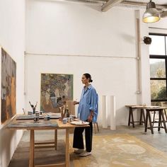 a woman is standing in an art studio