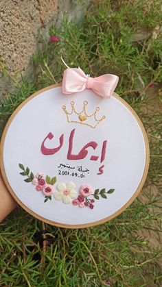 a hand is holding up a embroidery hoop