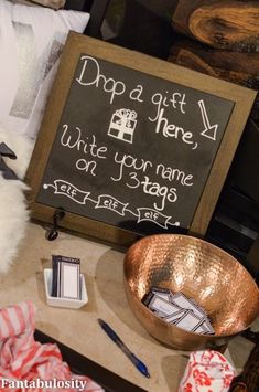 a blackboard with writing on it next to a copper bowl and other items that are sitting on a table