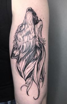 a woman's arm with a wolf tattoo on it