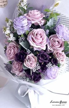 a bouquet of pink and purple flowers sitting on top of a white cloth covered table