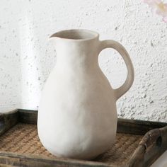 a white vase sitting on top of a tray