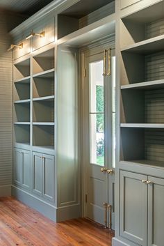 an empty room with built in bookshelves and wood flooring on the side