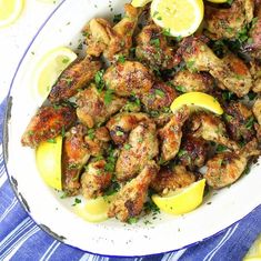 chicken wings with lemons and parsley in a white bowl