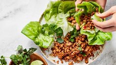 lettuce wraps with ground beef and cilantro on a plate next to two small bowls