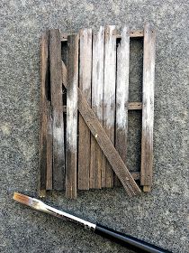 a piece of wood sitting on top of a floor next to a paintbrush