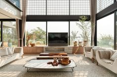 a living room filled with furniture and large windows