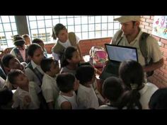 a group of people standing around each other in front of a laptop