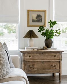 a living room scene with focus on the chest of drawers and plants in vases