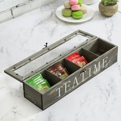 a wooden box filled with treats sitting on top of a table