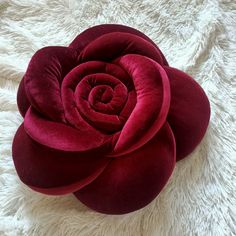 a large red flower sitting on top of a white rug