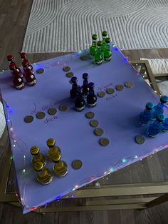 a table that has some bottles on top of it and coins around the edges with lights