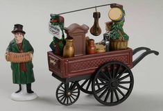 a small figurine is standing next to a toy wagon