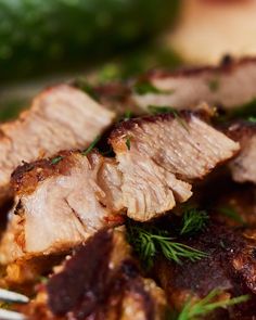 some meat is sitting on a plate with a fork in it and garnished with parsley