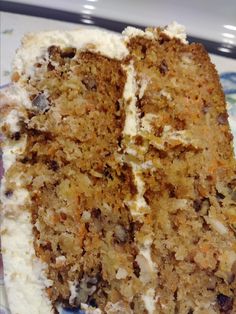 a piece of carrot cake with cream cheese frosting on a blue and white plate