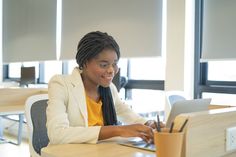 a woman sitting at a desk using a laptop computer