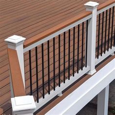 a white bench sitting on top of a wooden deck next to a fenced in area