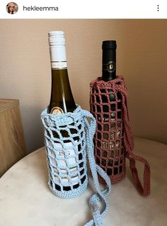 two crocheted wine bottles sitting next to each other on top of a table