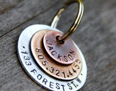 three personalized copper and silver discs with names on them sitting on a wooden surface