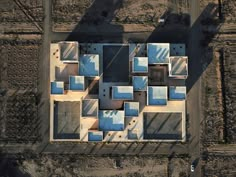 an aerial view of a building in the middle of a dirt area with several windows