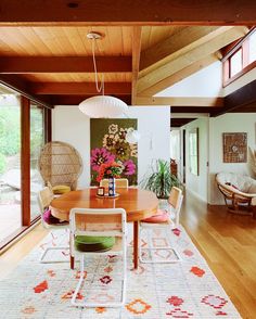 a dining room table with chairs and a rug on the floor