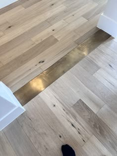 a pair of black shoes sitting on top of a wooden floor next to a sink