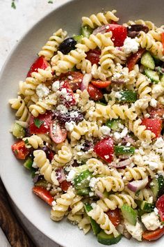 a white bowl filled with pasta salad on top of a table