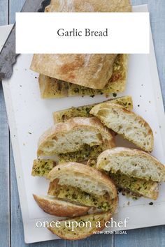 garlic bread on a white plate next to a knife and napkin with the words garlic bread