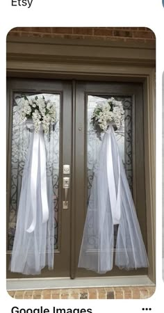 two doors decorated with white flowers and tulle for the bride and groom to enter