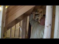 a man is working on the framing of a house under construction with wooden beams and plywood