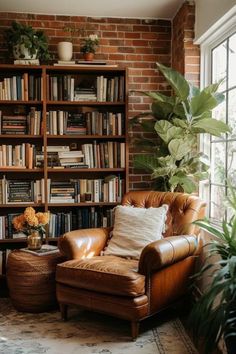 a chair and ottoman in front of a book shelf with books on it, surrounded by potted plants