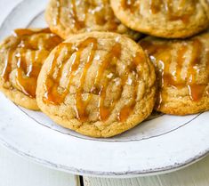 cookies with caramel drizzled on them sitting on a plate