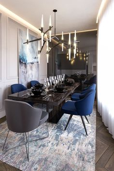 a dining room table with blue chairs and a chandelier hanging from the ceiling