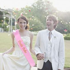 a man and woman are holding hands while confetti is thrown in the air