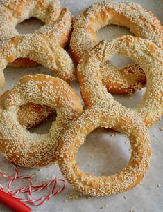 four bagels with sesame seeds and sprinkles on a piece of parchment paper