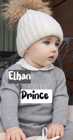 a baby sitting on top of a chair wearing a white hat and grey sweater with the words prince written across it