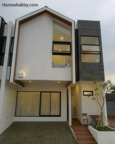 a modern house with white walls and black trim on the front, windows and doors