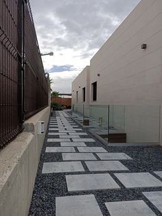 an empty walkway between two buildings on a cloudy day