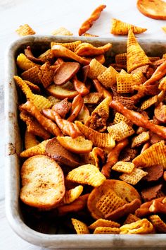 a pan filled with cheetos and chips on top of a table