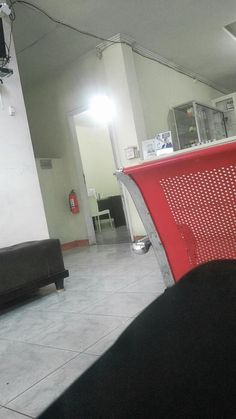 a red bench sitting in the middle of a room next to a microwave and table