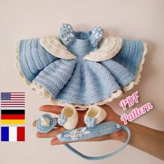 a crocheted baby outfit and booties is being held by someone's hand