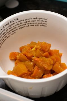 a white bowl filled with food on top of a table