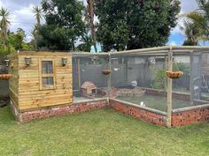 a chicken coop in the middle of some grass