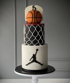 a three tiered cake decorated with basketballs and hoop